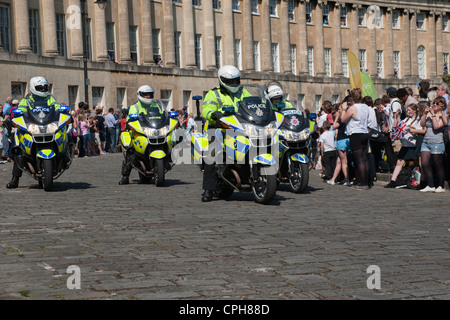 Metropolitan police motorcycle riders provide an escort to the 2012 Olympic torch relay as it passes through the city of Bath. Stock Photo