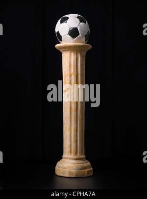Old football ball on a pedestal Stock Photo