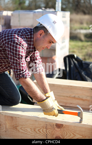 Man working on large wooden structure Stock Photo