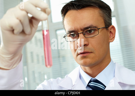 Male scientist in eyeglasses studying a substance Stock Photo