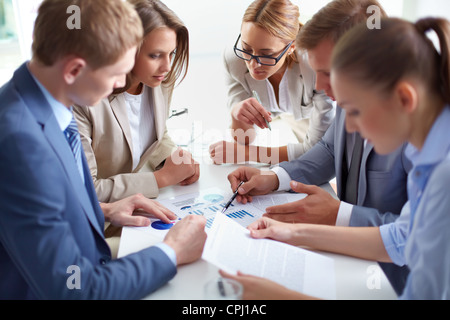 Image of business partners discussing documents at meeting Stock Photo