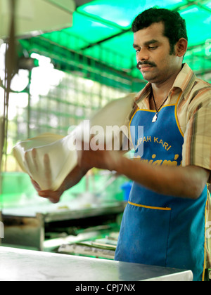 A street vendor preparing traditional Indian Roti Canai flatbread Stock Photo