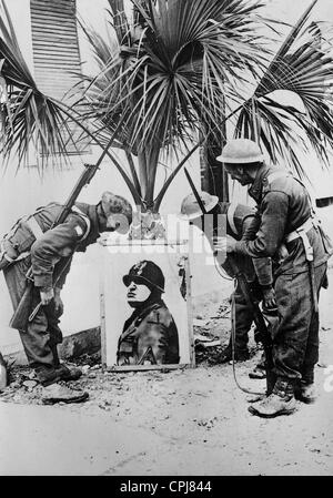 British soldiers examining a portrait of Mussolini, following the capture of the Italian military fortification at Bardia, Stock Photo