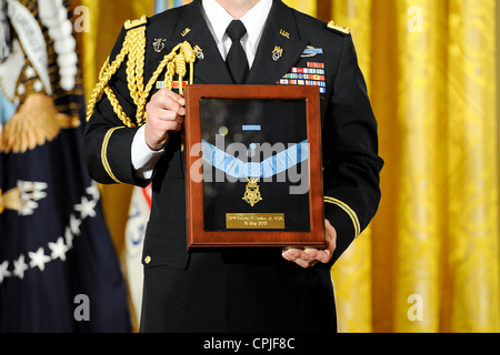 An Army officer holds the medal of honor during the and award ceremony in honor of Leslie H. Sabo Jr., at the White House May 16, 2012 in Washington, DC. Sabo a soldier with the 101st Airborne Division was posthumously awarded the Medal of Honor for valor in Vietnam. Stock Photo