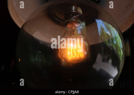 Low wattage large glowing light bulb filament in a café Stock Photo