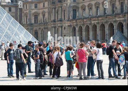 Paris, France -  A group of students visiting Paris in front of the Louvre Museum. Stock Photo
