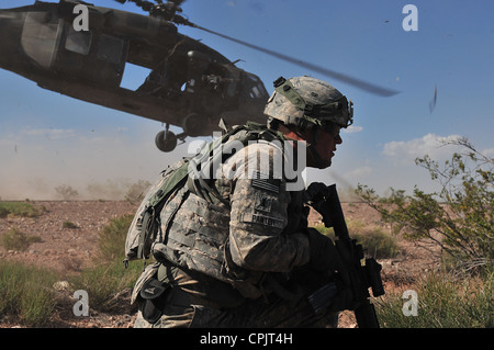 US Army solider moves to secure the landing zone during an air artillery raid training mission May 20, 2012 in White Sands Missile Range, NM. Stock Photo