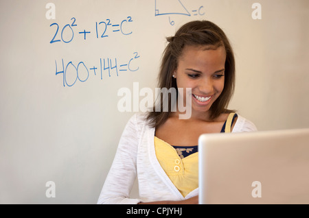 Teenage African American girl works on a laptop computer in math class. Stock Photo