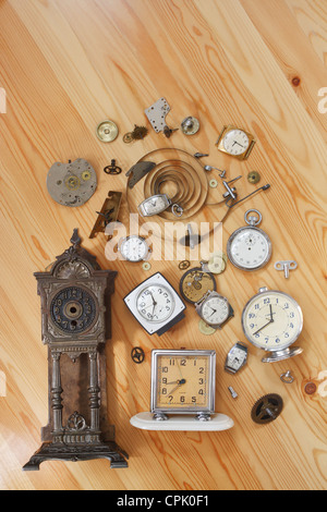 The old alarm clocks, watches and details of clock on a wooden surface Stock Photo