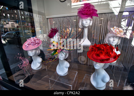 Fancy women's hats on display on mannequin heads in a shop window in New York city, New York, USA. Stock Photo