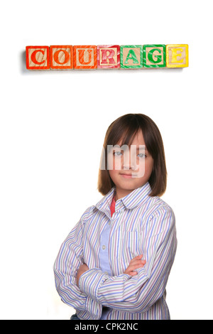 A young student showing courageous pose under word blocks. Stock Photo