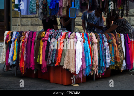 A selection of colorful scarves on display and for sale in Florence Italy at a market stall. Stock Photo