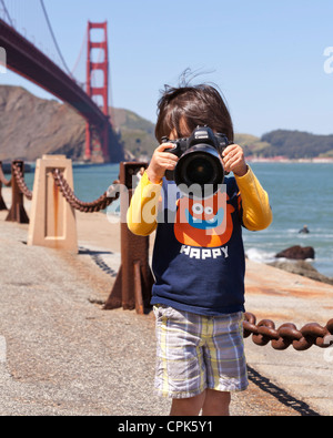 Child photographer taking pictures with dSLR camera - USA Stock Photo
