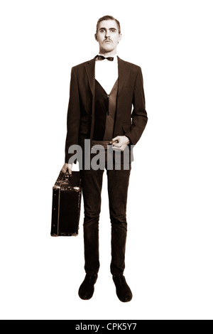 Retro portrait of a young man standing on a white background, with a suitcase isolated on white background Stock Photo