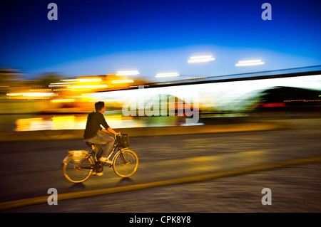 Panning shot of a cyclist by Tirana Bridge, Seville, Spain Stock Photo