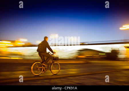 Panning shot of a cyclist by Tirana Bridge, Seville, Spain Stock Photo