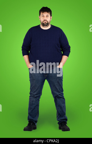 Complete body shot of a big guy looking at camera, real ordinary middle age man with weight problem in front of green screen Stock Photo