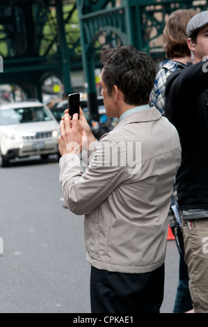 Ben Stiller who is directing and starring in The Secret Life of Walter Mitty seen here checking video he has shot on his mobile Stock Photo