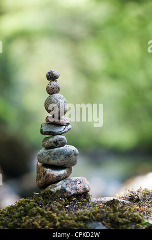 Stacked balanced stones on the edge of a river in the English countryside Stock Photo