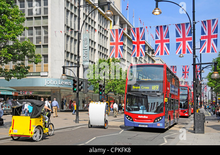 Rickshaws & red buses outside John Lewis department store Oxford Street Union Jack flags Queens Diamond Jubilee & 2012 Olympic Games London England UK Stock Photo