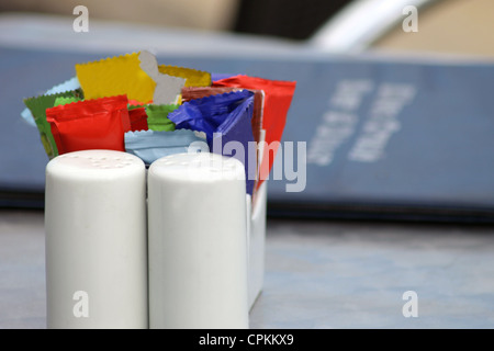 Condiments on table with menu, salt and pepper shakers Stock Photo