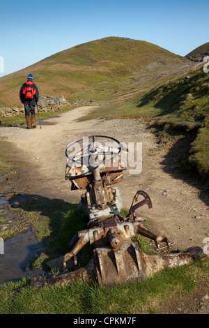 Man & Abandoned Farm Equipment, trails, paths, and Walker in the North Yorkshire National Park Pennine Way Track, near Keld, Richmondshire, UK Stock Photo