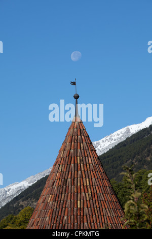 North west tower with weathervane of Schloss Goldrain with moon in sky, Alps, Italy Stock Photo