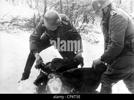 Soldiers of the Waffen SS on the Eastern front search a liquidated Jewish partisan, 1942 Stock Photo