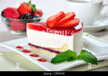 piece of strawberry cheesecake on white plate with coffee cup Stock Photo