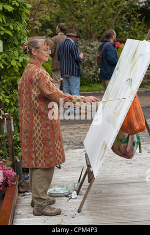 Woman painting garden at Chelsea Flower Show 2012. Stock Photo