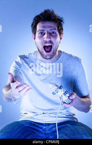 Shocked Man Playing Videogames with Gamepad Stock Photo