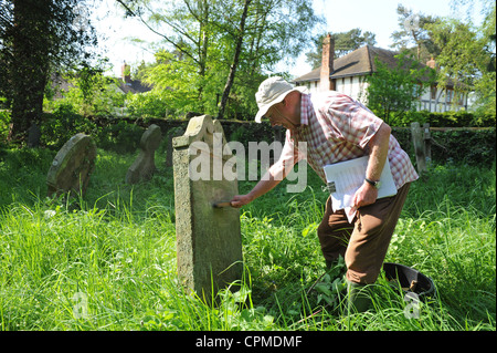 Genealogist David Petley-Jones cleaning a gravestone at Worthen church yard Uk Stock Photo