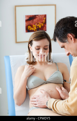ABDOMEN PALPATION PREGNANT WOMAN Stock Photo