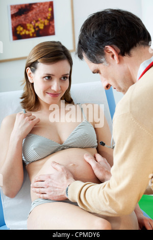 ABDOMEN PALPATION PREGNANT WOMAN Stock Photo