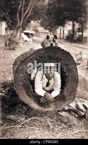 Man & Dog Posing with Hollowed Out Log Stock Photo