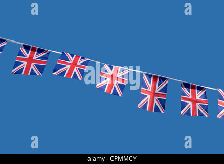 Small British Union Jack celebration flags against a blue sky. Stock Photo