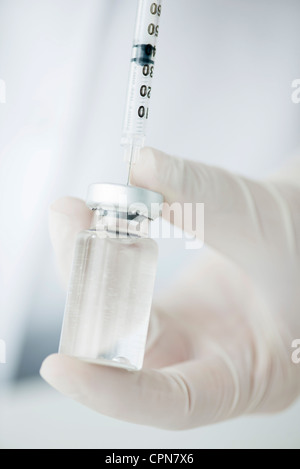 Extracting liquid from vial with syringe Stock Photo