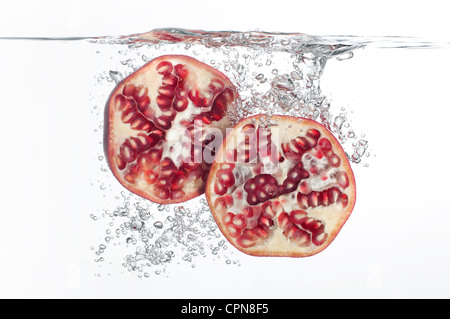 Pomegranate halves submerged in water Stock Photo