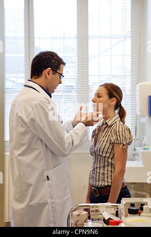 WOMAN PALPATING LYMPH NODE Stock Photo