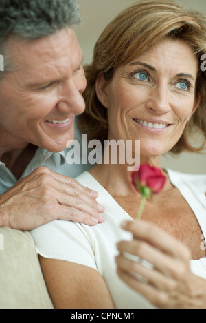 Mature couple together, woman holding rose Stock Photo
