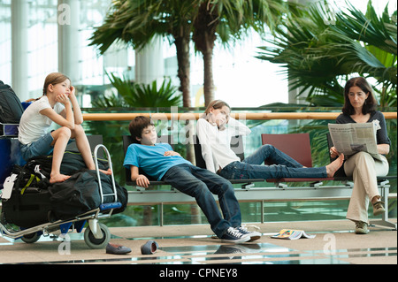Family waiting in airport terminal Stock Photo