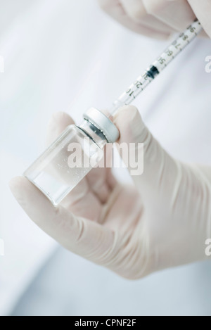 Extracting liquid from vial with syringe Stock Photo