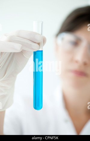 Scientist holding test tube containing blue liquid Stock Photo