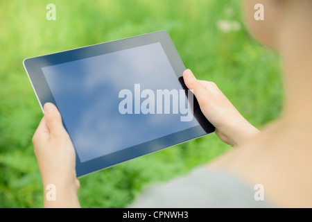 Woman using digital tablet PC in the park. Stock Photo