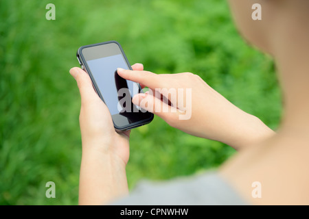 Woman using mobile smart phone in the park. Stock Photo