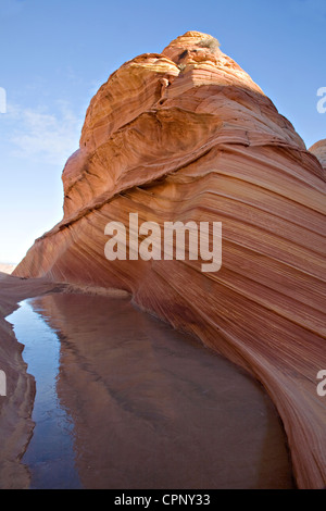 A striated rock formation near the Wave rises out of an icy seasonal water pocket, Coyote Buttes North, Arizona Stock Photo
