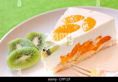 A delicious cake with clementine and kiwi on a bed of biscuits Stock Photo