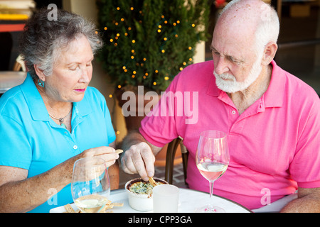 Senior couple dining out, looking serious and not very happy.  Stock Photo