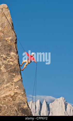 Rock climber rappels from the summit after a successful ascent. Stock Photo