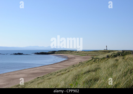 A distant Turnberry lighthouse located at the end of the long sweeping beach on the left and golf course on the right. Stock Photo